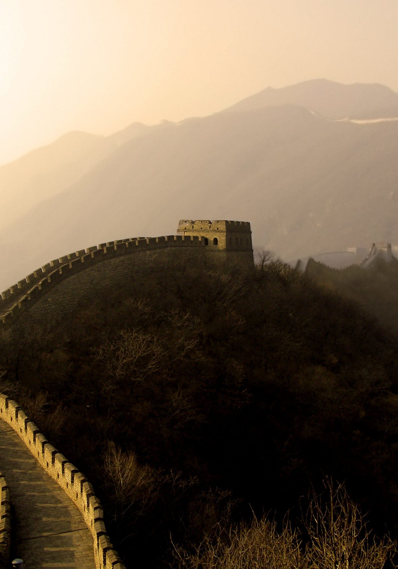 the great wall of china (mu tian yu) under a setting sun.